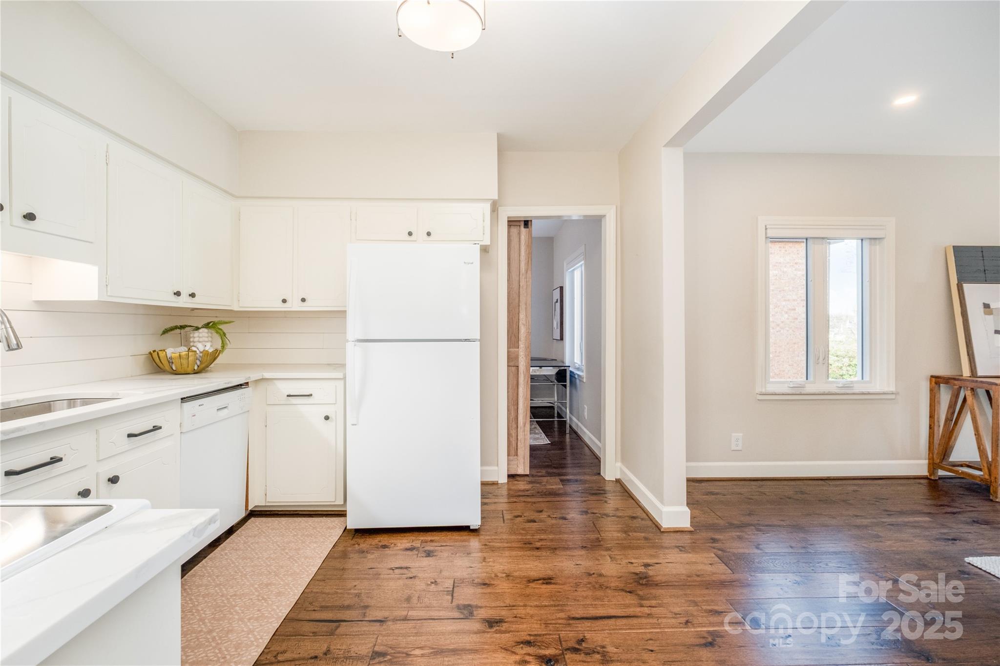4527 Gaynor Road, Unit 303 Charlotte, NC 28211 - Photo 7 of 28 a kitchen with a refrigerator a stove and wooden floor