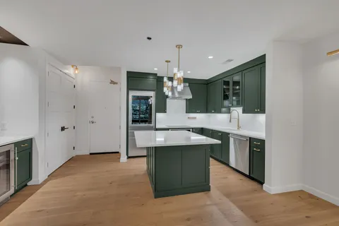 a kitchen with kitchen island a sink stainless steel appliances and cabinets