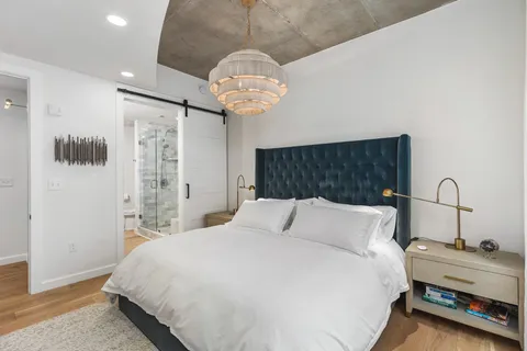a bedroom with a bed and a chandelier