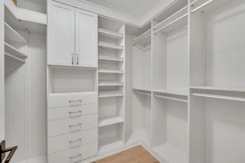 a view of walk in closet with empty racks