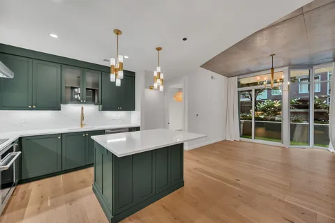 a kitchen with kitchen island sink and refrigerator