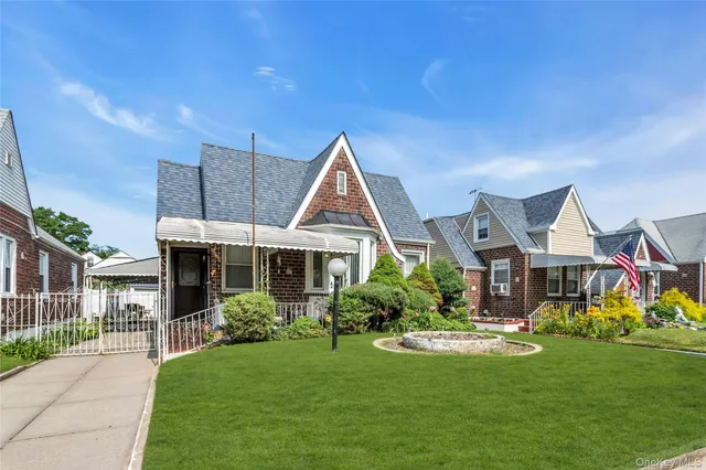 a front view of a house with a yard and potted plants
