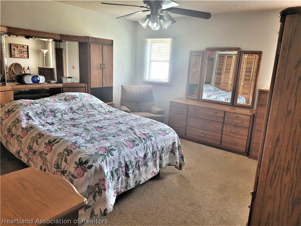 641 South Lakeview Road Lake Placid, FL 33852 - Photo 10 of 15 a bedroom with a bed and a large mirror on dresser