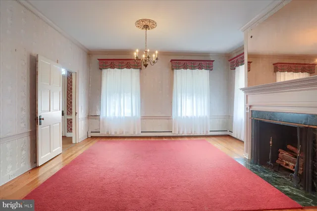 a view of a livingroom with a fireplace a chandelier and a rug