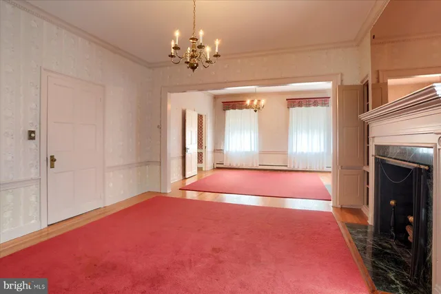 a view of an empty room with fireplace and fan