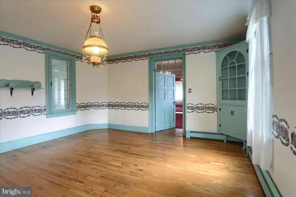 a view of a hallway with wooden floor and a living room