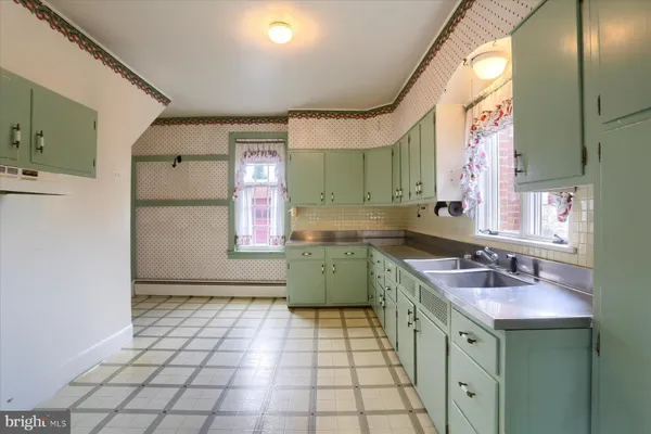 a kitchen with a sink a stove cabinets and counter space