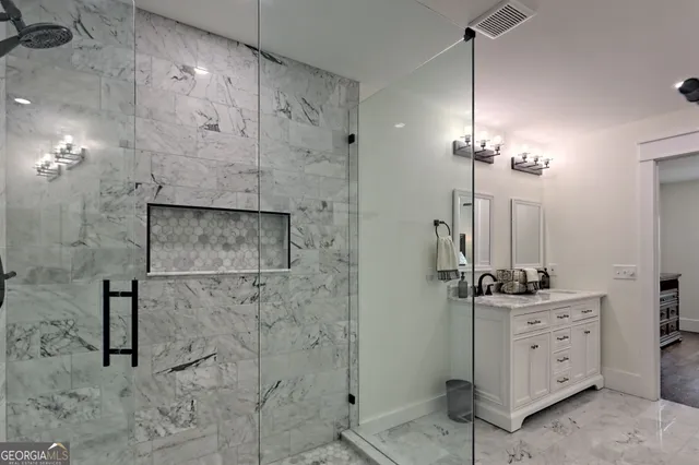 a bathroom with a granite countertop toilet sink and mirror