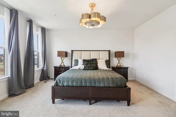 a bedroom with a bed and a lamp on dresser
