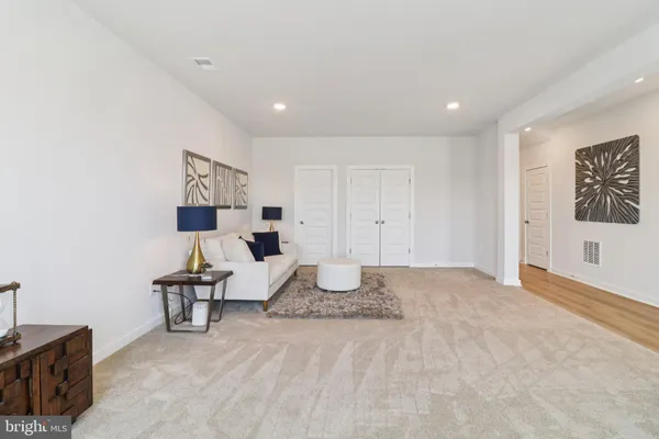 a spacious bedroom with a bed a couch and dresser