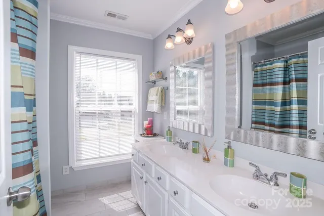 a bathroom with double vanity and a window