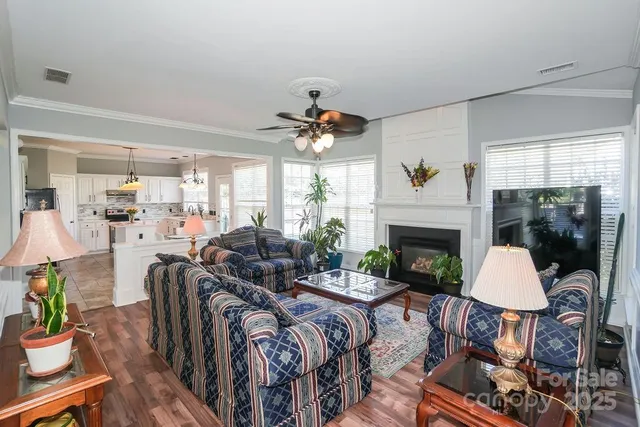 a living room with furniture a fireplace and a chandelier