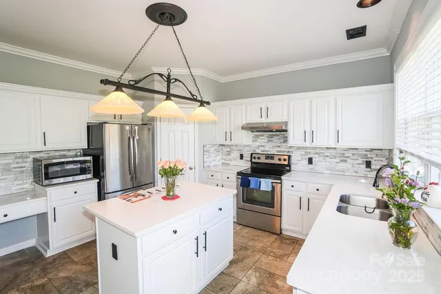 a kitchen with a sink a counter top space appliances and cabinets