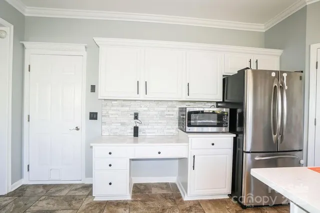 a kitchen with white cabinets and stainless steel appliances