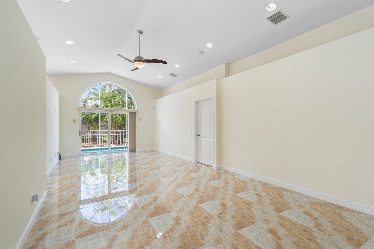 9547 Fox Trot Lane Boca Raton, FL 33496 - Photo 14 of 38 en empty room with windows and chandelier