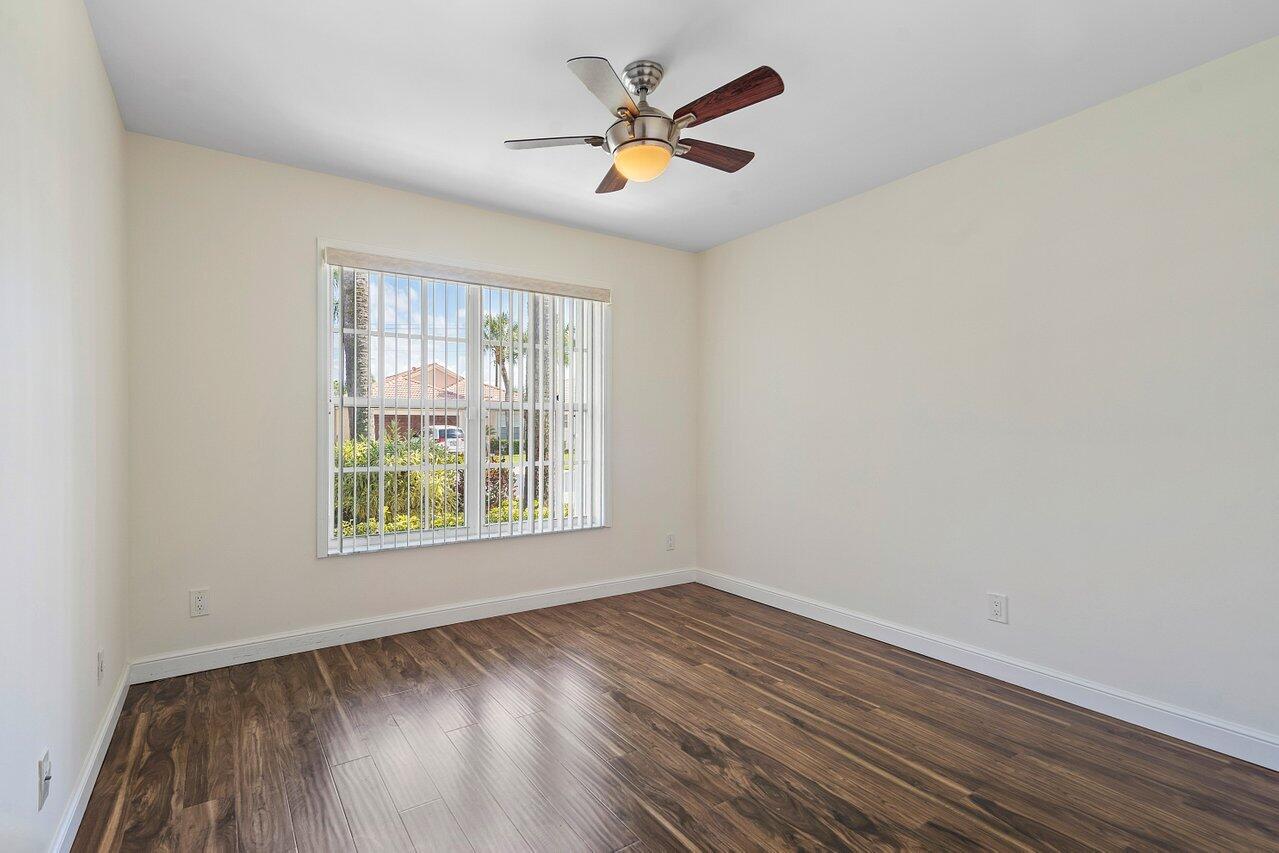 9547 Fox Trot Lane Boca Raton, FL 33496 - Photo 18 of 38 an empty room with wooden floor and windows