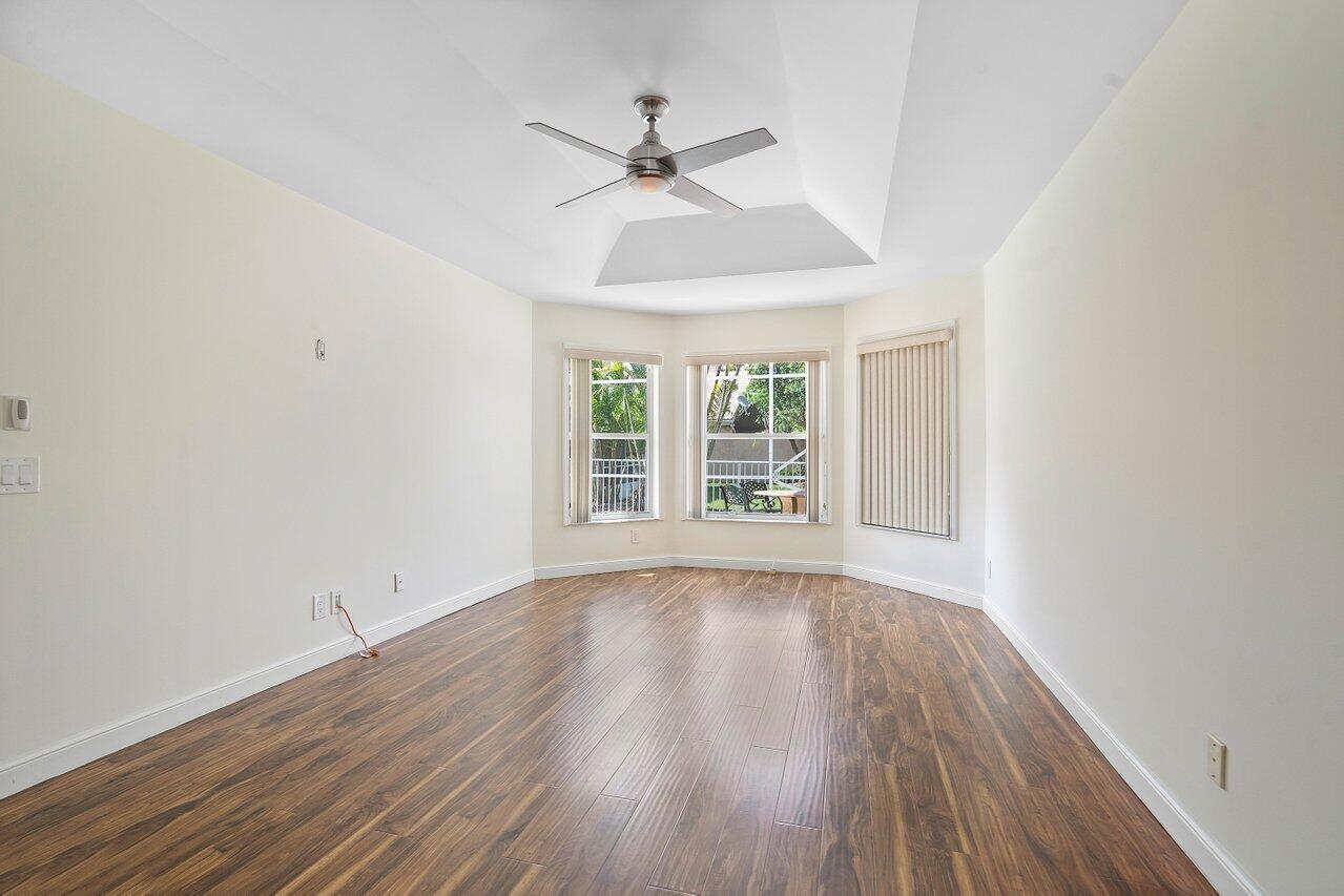 9547 Fox Trot Lane Boca Raton, FL 33496 - Photo 21 of 38 an empty room with wooden floor chandelier fan and windows