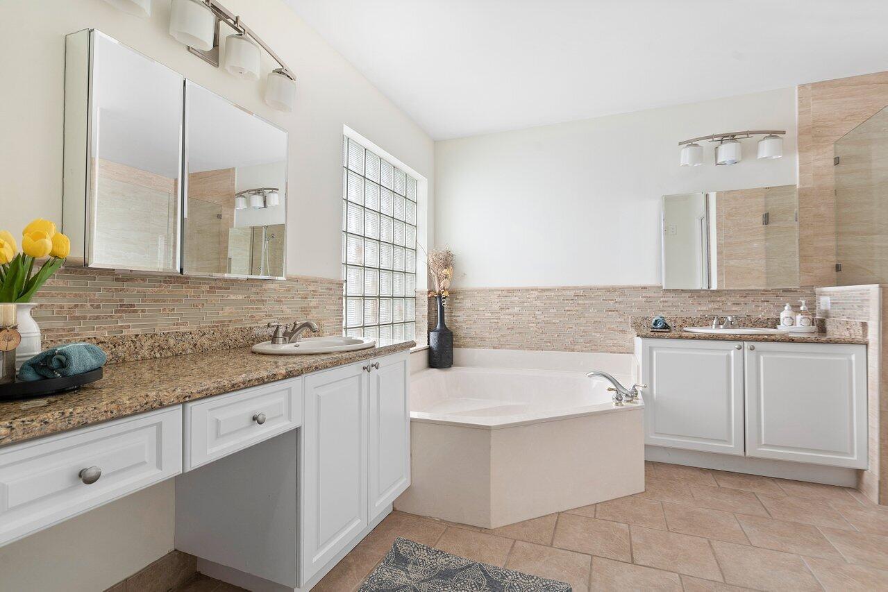 9547 Fox Trot Lane Boca Raton, FL 33496 - Photo 23 of 38 a bathroom with a granite countertop bathtub sink and mirror