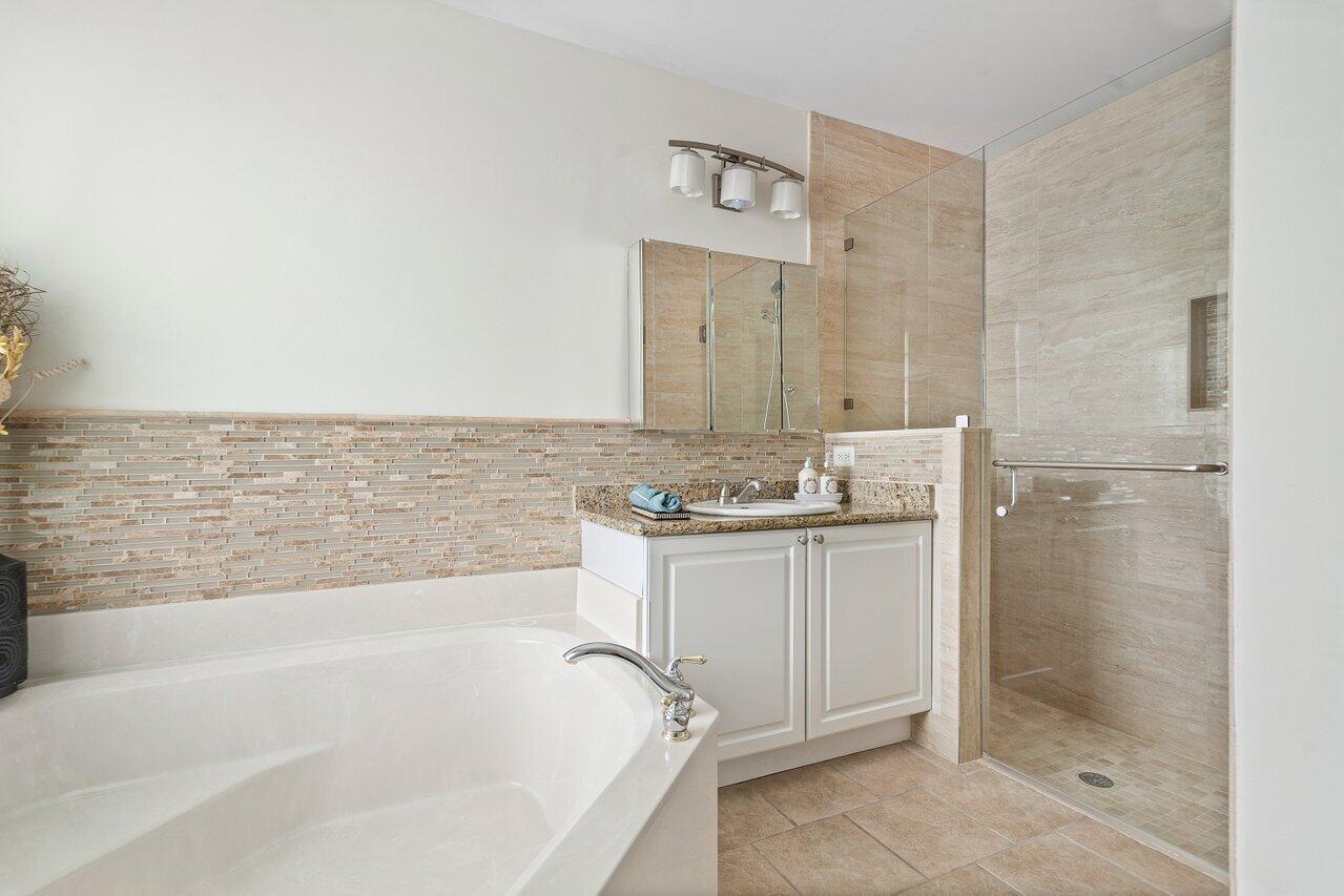 9547 Fox Trot Lane Boca Raton, FL 33496 - Photo 24 of 38 a bathroom with a bathtub sink and mirror