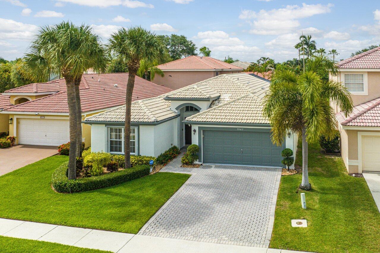 9547 Fox Trot Lane Boca Raton, FL 33496 - Photo 29 of 38 a front view of a house with a garden and plants