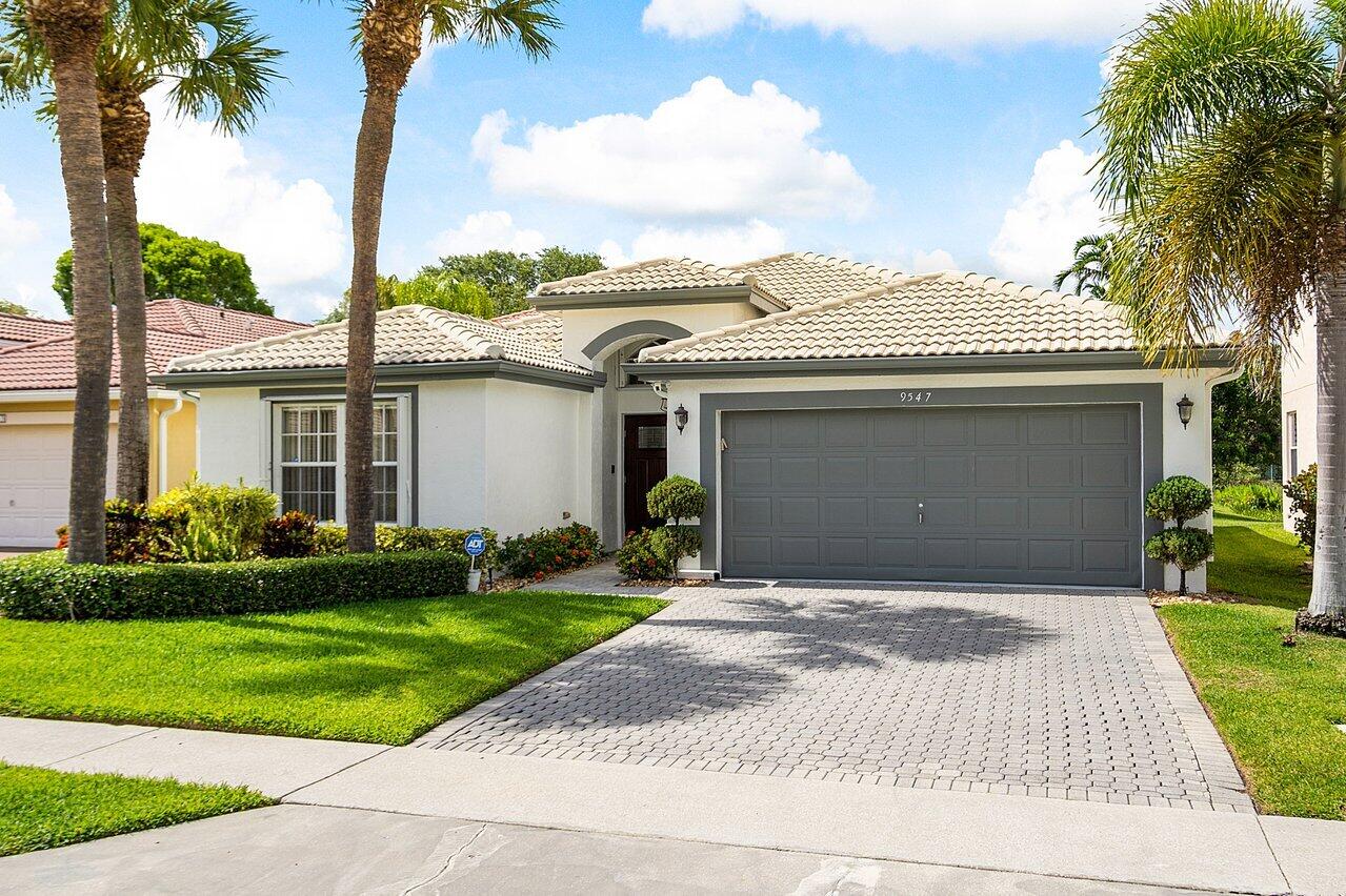 9547 Fox Trot Lane Boca Raton, FL 33496 - Photo 3 of 38 a front view of a house with a garden and yard