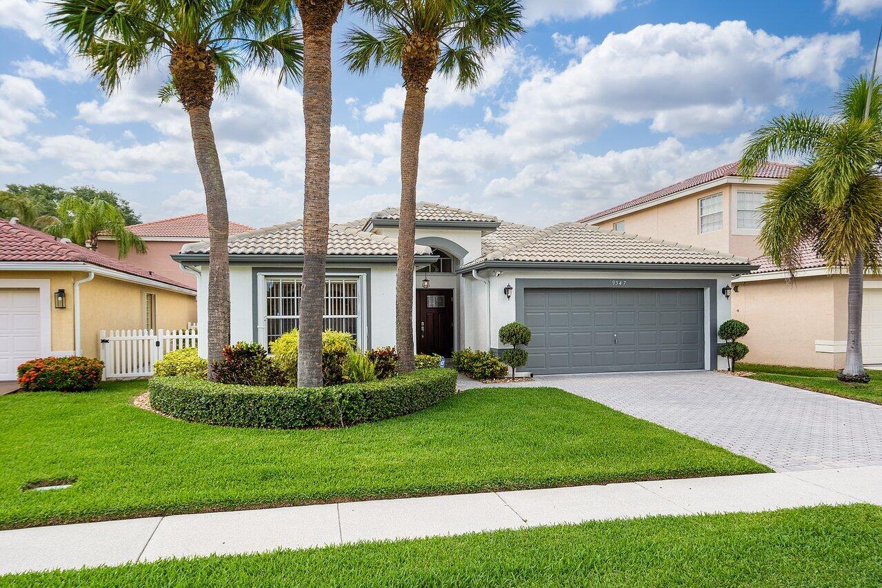 9547 Fox Trot Lane Boca Raton, FL 33496 - Photo 4 of 38 a front view of a house with a garden and yard