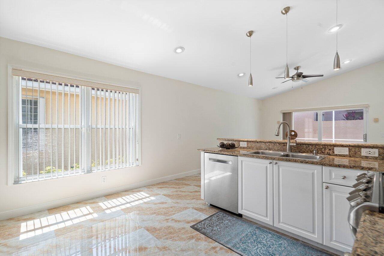 9547 Fox Trot Lane Boca Raton, FL 33496 - Photo 8 of 38 a kitchen with granite countertop a sink and a stove