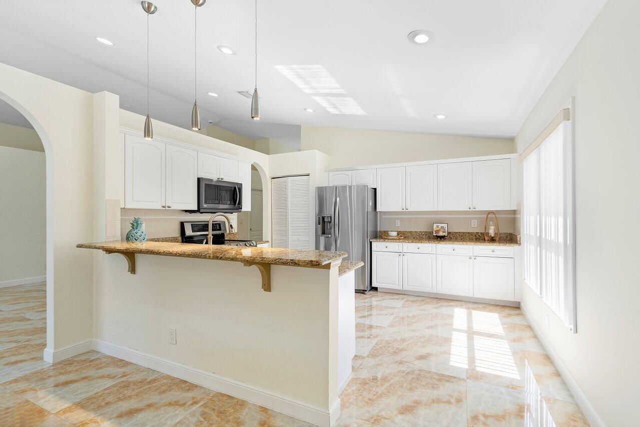 9547 Fox Trot Lane Boca Raton, FL 33496 - Photo 10 of 38 a large white kitchen with lots of counter space a sink appliances and cabinets
