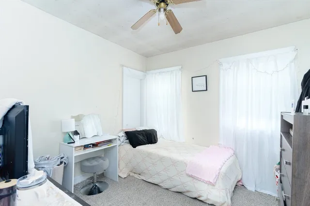 a bedroom with a bed and a flat tv screen on the dresser