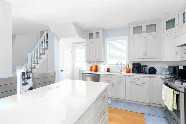 a large white kitchen with cabinets and wooden floor