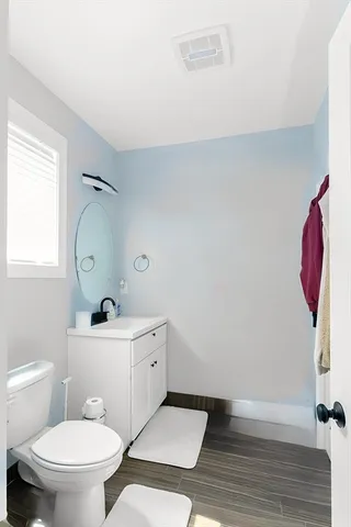 a bathroom with a toilet a sink and mirror