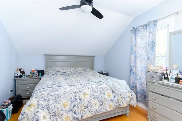 a bedroom with a bed and dresser with mirror