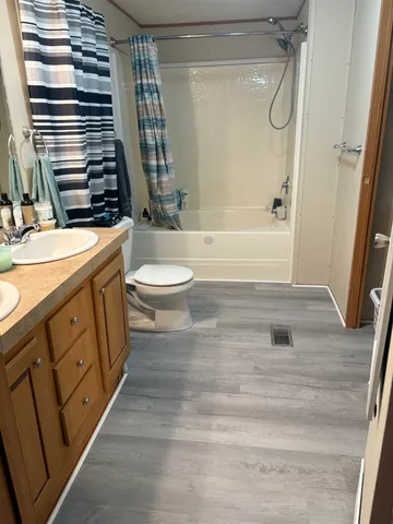 a bathroom with a granite countertop sink toilet and shower