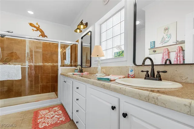 a bathroom with a double vanity sink mirror and shower