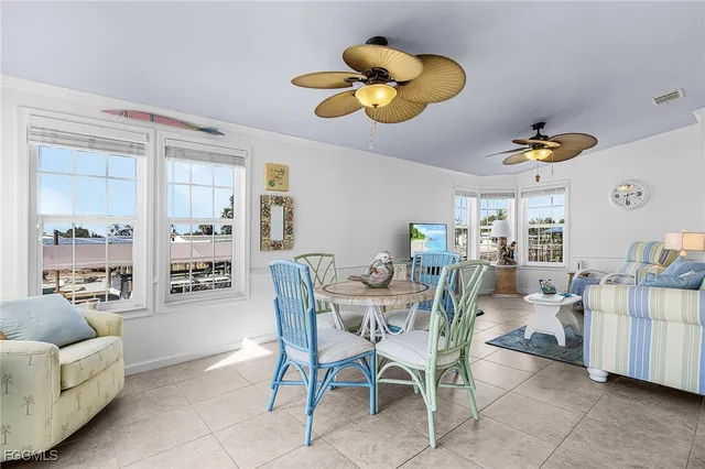a view of a dining room and livingroom with furniture wooden floor and a large window