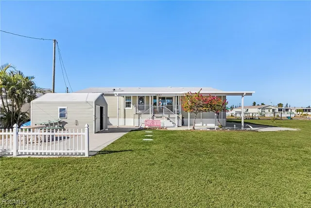 a view of a house with a yard and sitting area