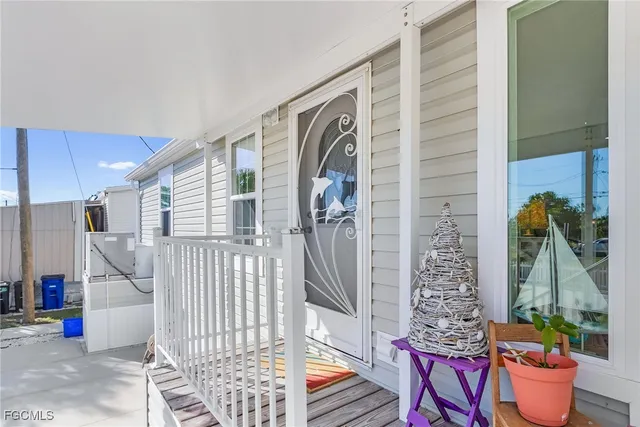a view of a porch with a potted plant and floor to ceiling window