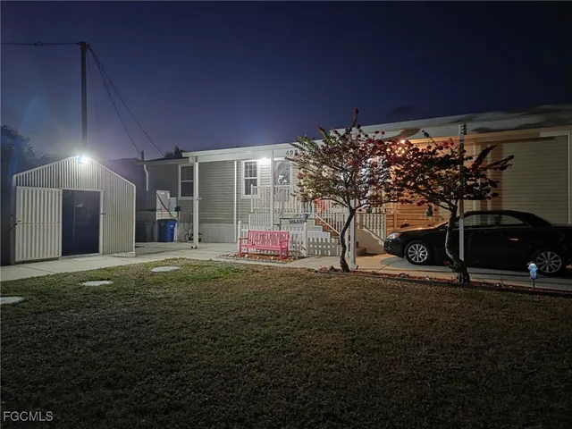 a backyard of a house with barbeque oven table and chairs