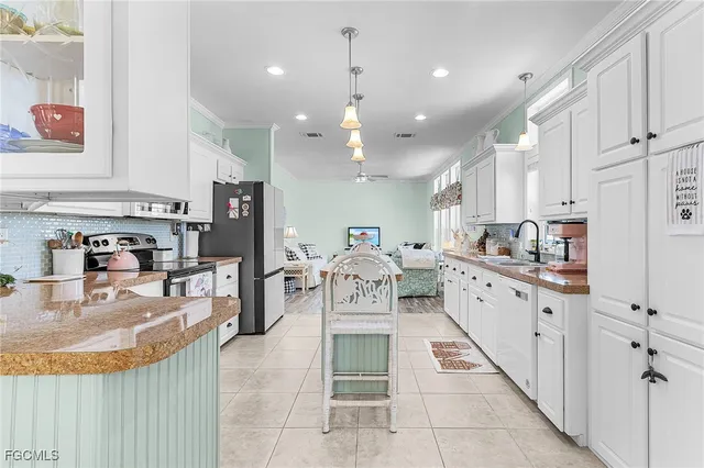 a kitchen with stainless steel appliances kitchen island granite countertop a stove a sink and a refrigerator