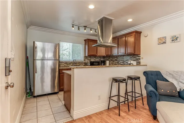 a kitchen with stainless steel appliances granite countertop a refrigerator and a stove top oven