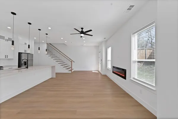 a view of an empty room with a fireplace and a window