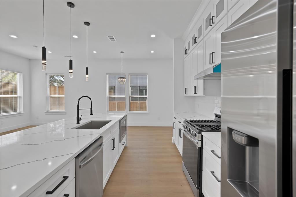 308 East 7th Street Dallas, TX 75203 - Photo 18 of 33 a kitchen with stainless steel appliances a sink stove and cabinets