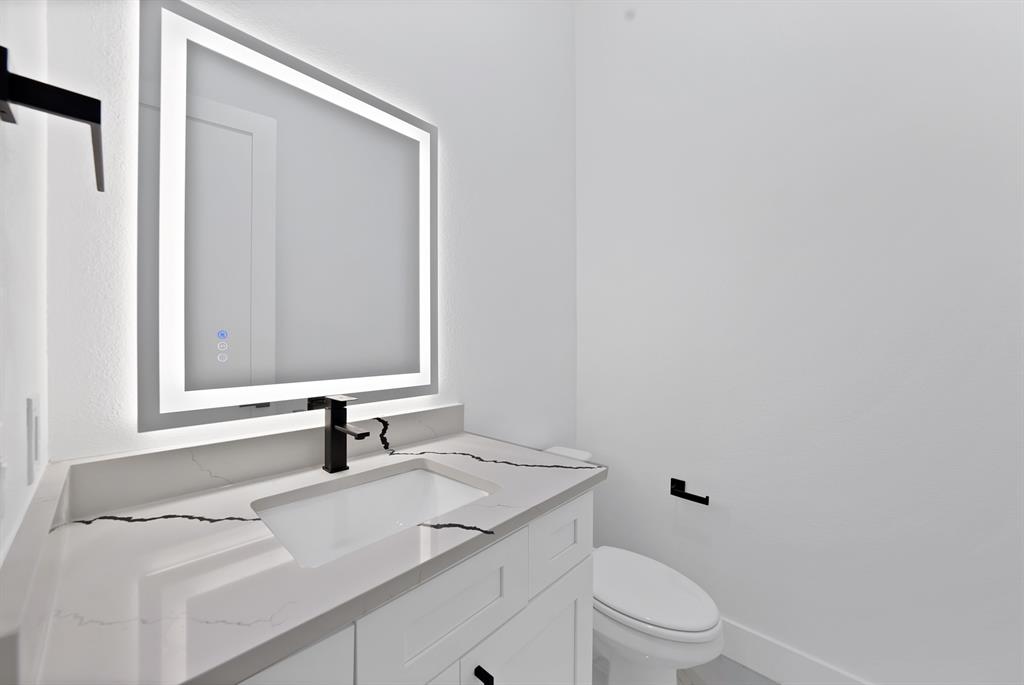 308 East 7th Street Dallas, TX 75203 - Photo 20 of 33 a bathroom with a sink toilet vanity and mirror