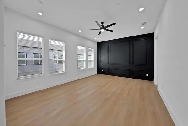 a view of empty room with a ceiling fan and window