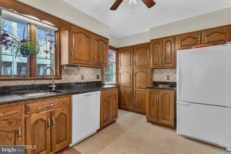 535 Carroll Fox Road Brick, NJ 08724 - Photo 14 of 31 a kitchen with stainless steel appliances granite countertop a refrigerator a sink dishwasher a stove with wooden cabinets and floor