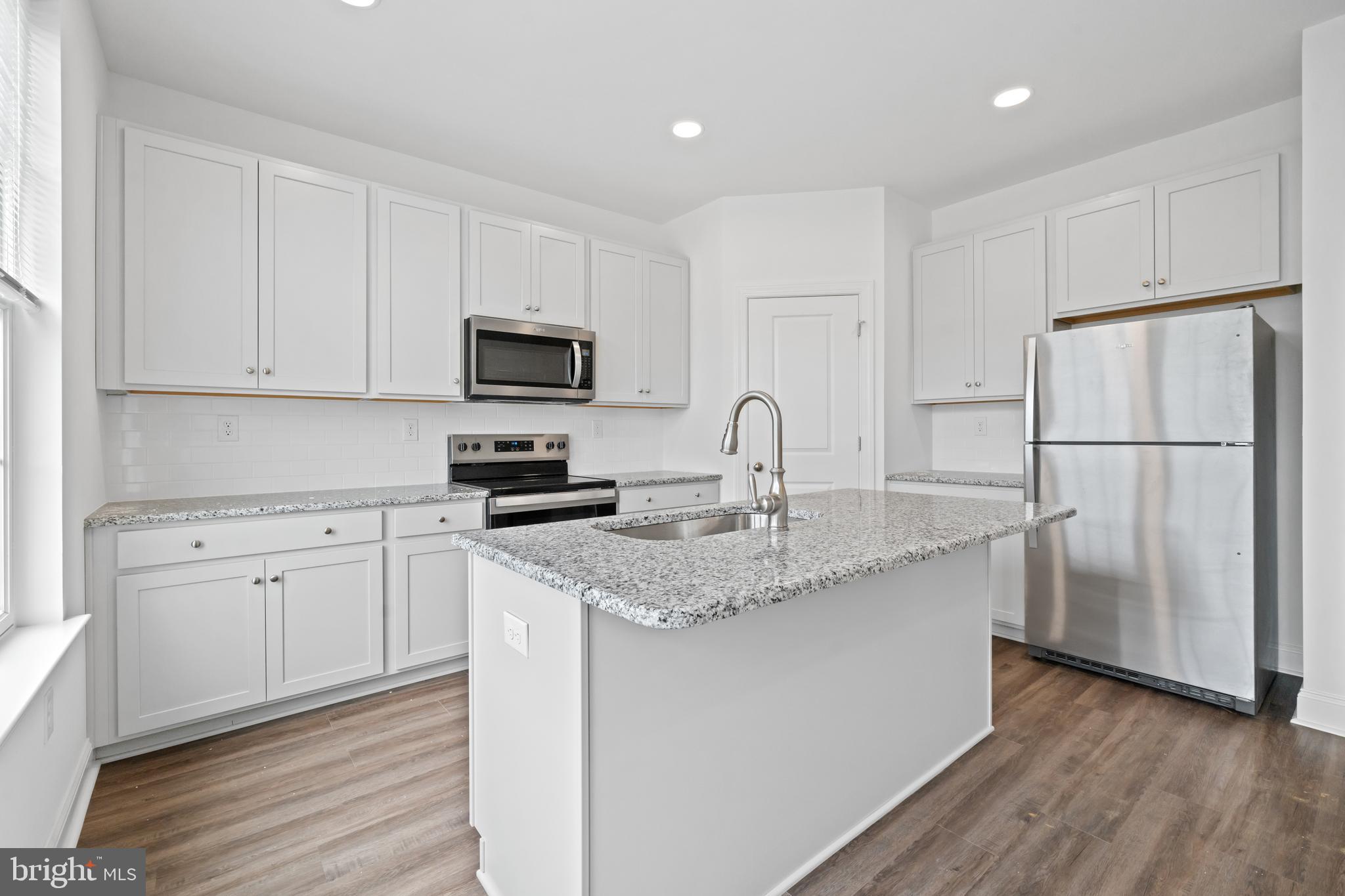 845 Mapleton Avenue Middletown, DE 19709 - Photo 12 of 30 a kitchen with a sink a refrigerator a microwave and cabinets