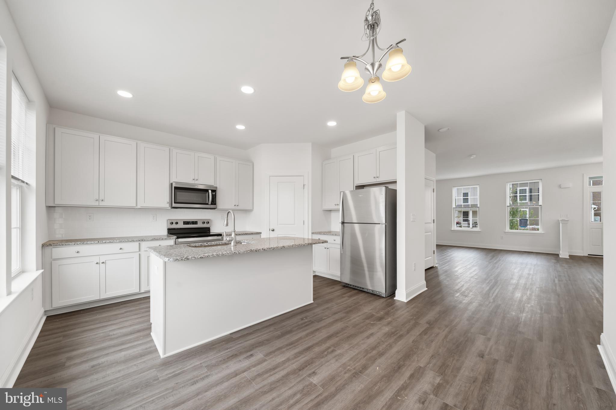 845 Mapleton Avenue Middletown, DE 19709 - Photo 14 of 30 a kitchen with stainless steel appliances a microwave a stove a refrigerator cabinets and wooden floor
