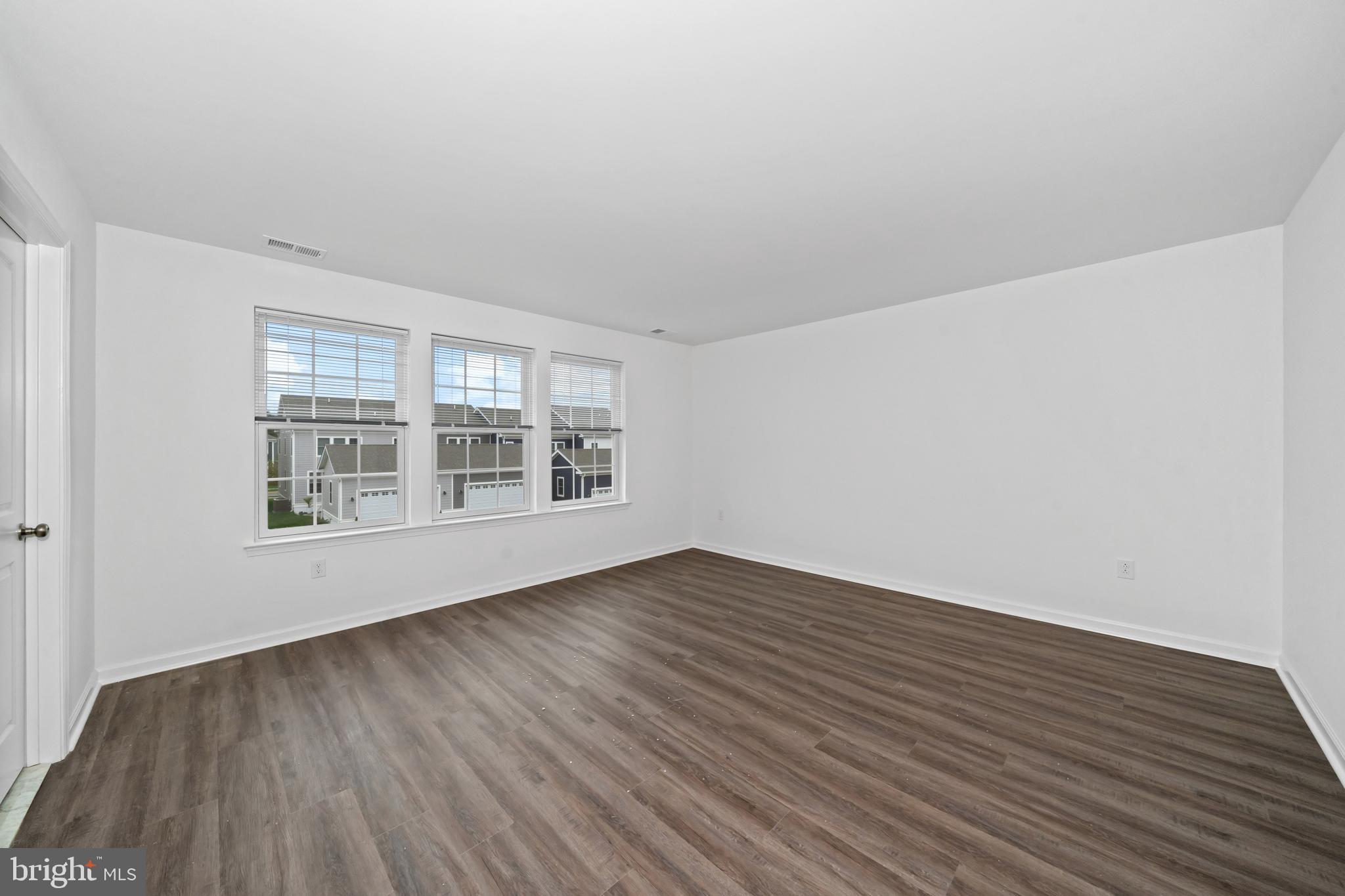 845 Mapleton Avenue Middletown, DE 19709 - Photo 17 of 30 a view of an empty room with wooden floor and a window