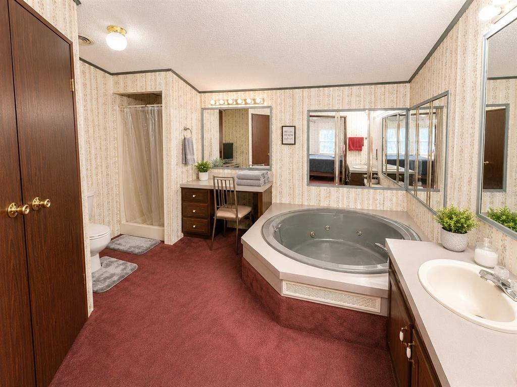 2665 Absher Road St. Cloud, FL 34771 - Photo 22 of 27 a spacious bathroom with a bathtub sink and mirror