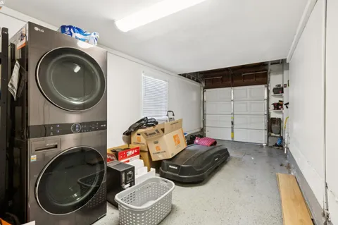 a utility room with dryer washer and a view of bedroom